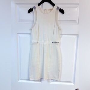 White mini dress with silver zipper and subtle netting detail.